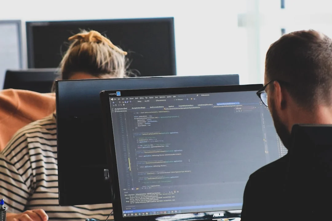 Stylish and efficient workspace with multiple monitors, laptop, and smartphone, showcasing a web design project.